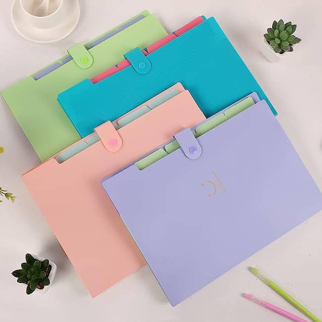 the four pastel folders with a snap closure in purple, pink, blue, and, green