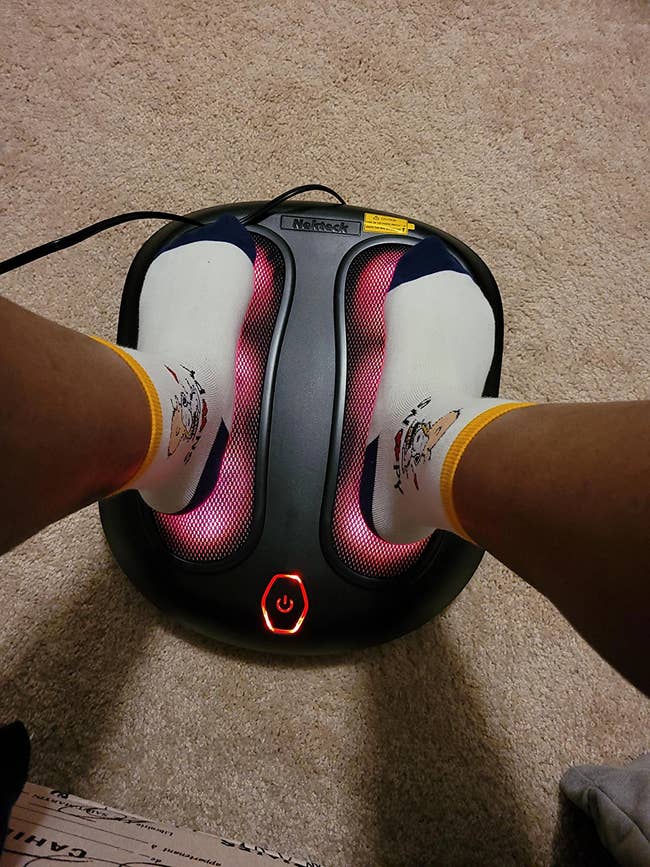 reviewer with feet on heated massager
