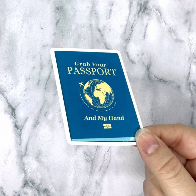 hand holding passport sticker with text 