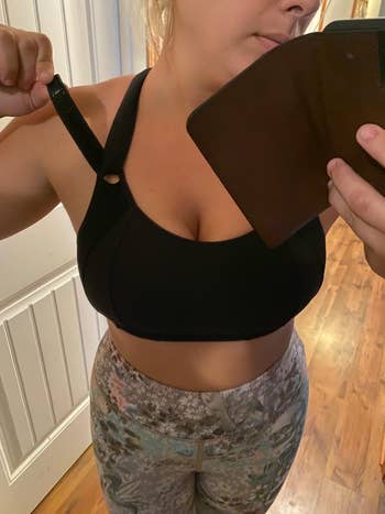 a reviewer showing the straps of the black bra