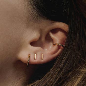model wearing hoop earrings and bar earrings