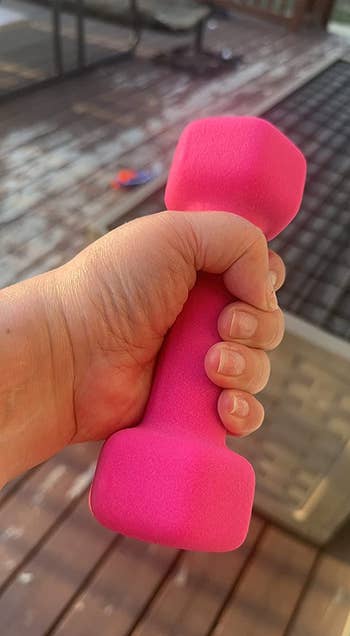 Reviewer holding their 2-pound pink dumbbell