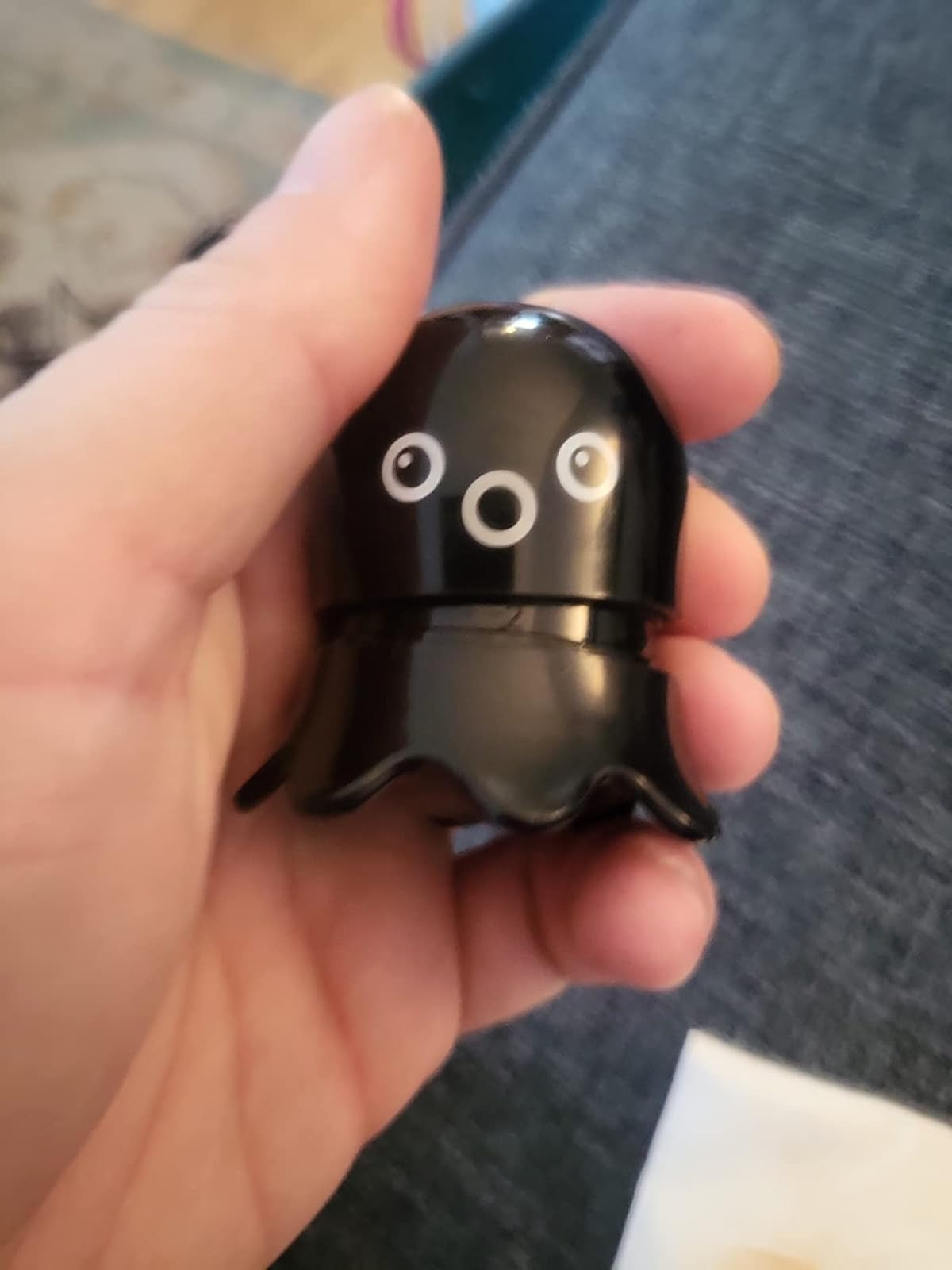 A hand holds a small octopus-shaped blackhead remover