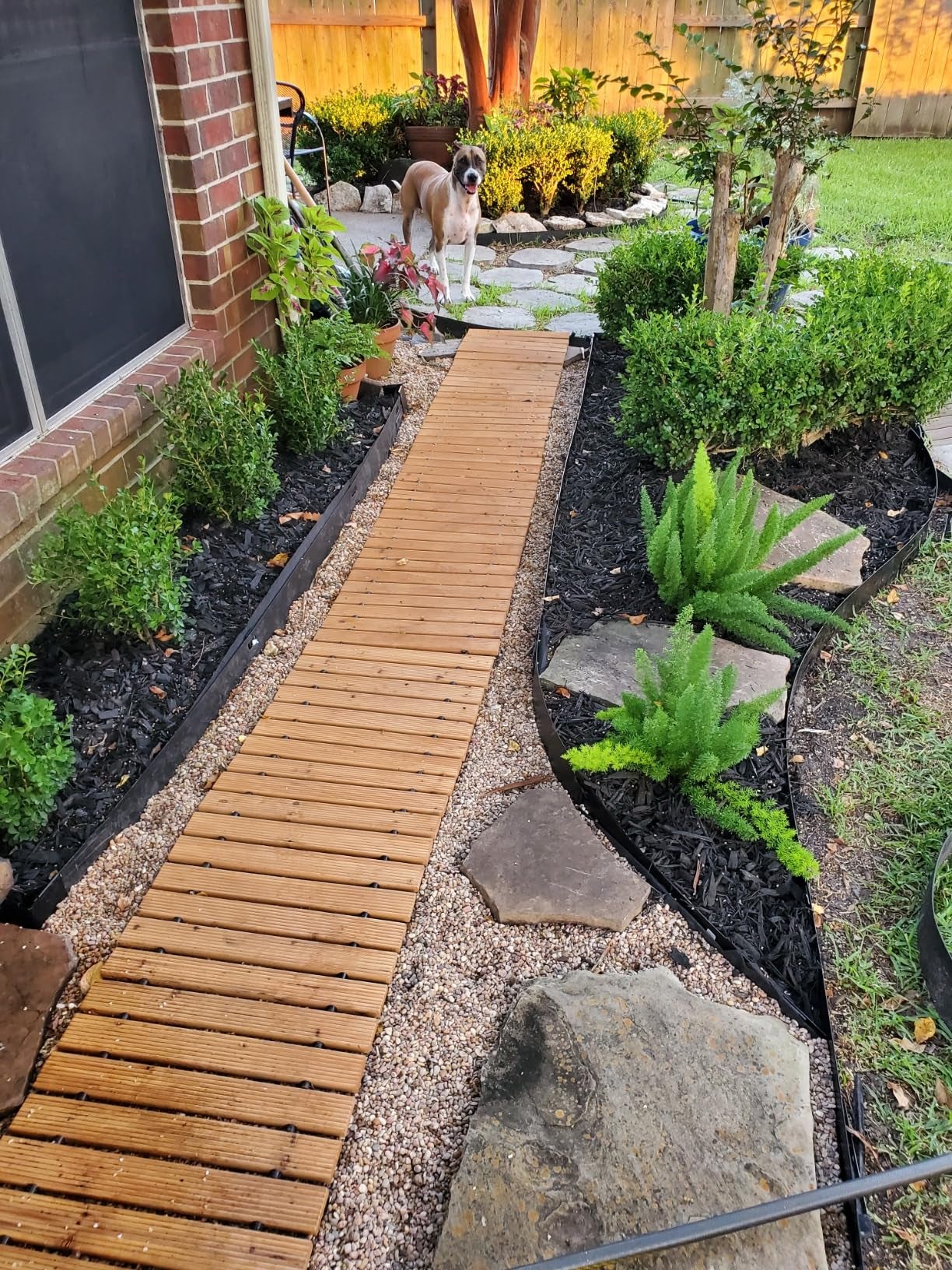 reviewer's wooden pathway in the garden with dog standing at the end
