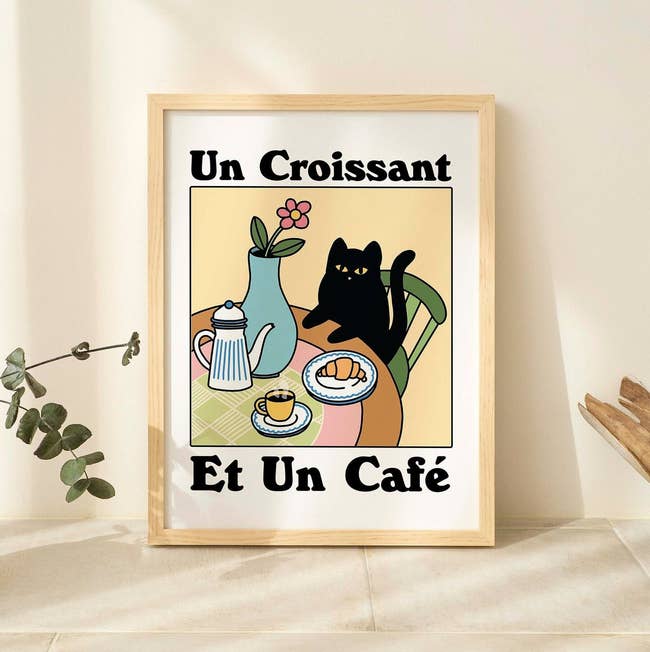 Illustration of a feline with a croissant and coffee, French text, successful a framework for location decor shopping