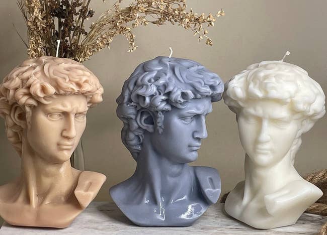 three of the david bust candles in different colors