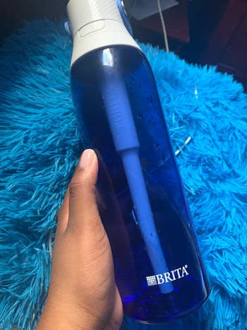 reviewer holding the sapphire water bottle