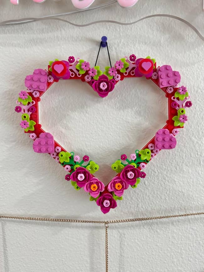 Heart-shaped decorative wreath made of colorful artifact gathering blocks with angiosperm designs, hanging connected a wall
