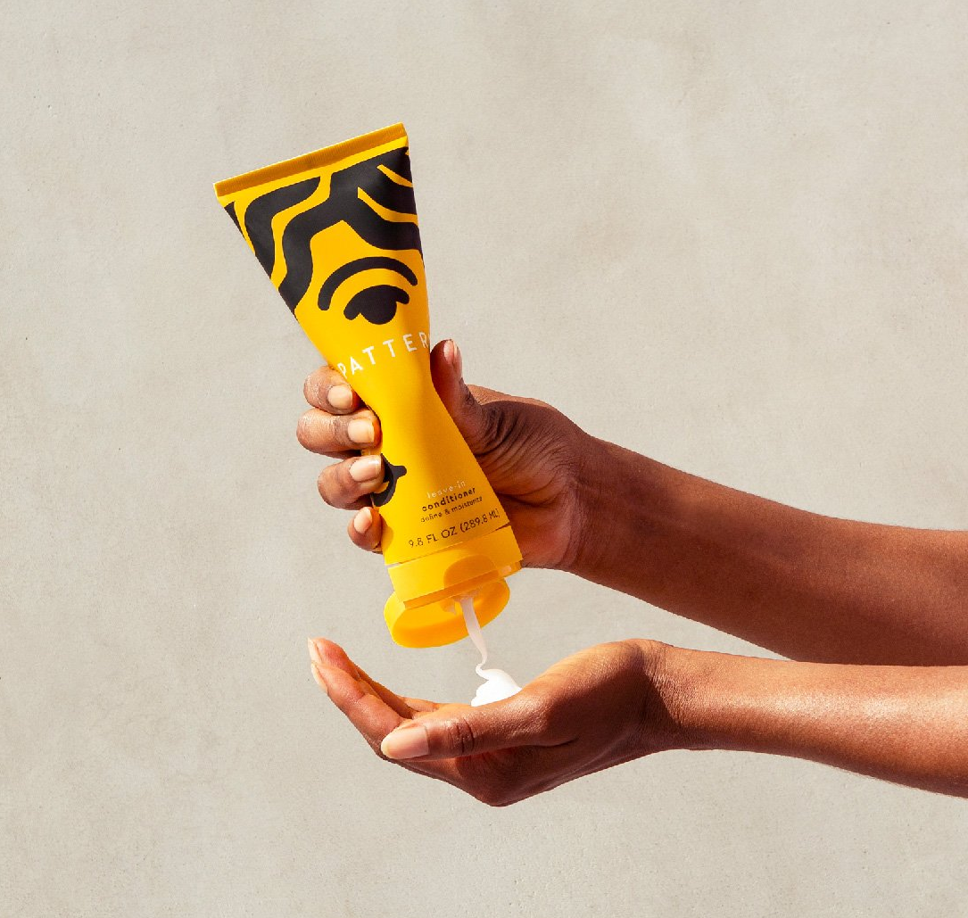 a model squeezing the leave-in conditioner into their hand