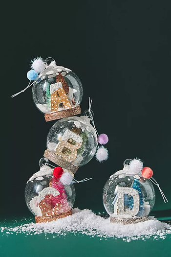 four initial snow globe ornaments stacked together
