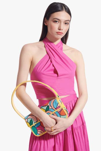 model holding the handbag, showing that it's a shoulder bag about the size of a loaf of bread