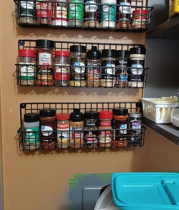 another reviewer's three racks hanging on pantry wall holding spices