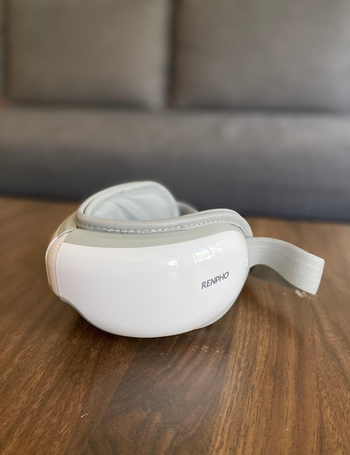 Same reviewer showing photo of eye massager on table