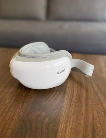 reviewer showing photo of eye massager on table