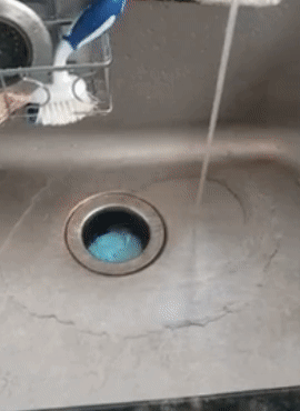 reviewer gif of the garbage disposal cleaner bubbling up into a blue foam in their sink