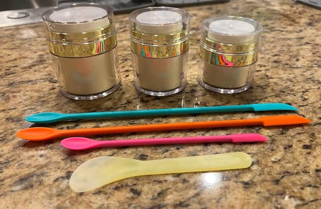 three cosmetic containers and silicone spatulas