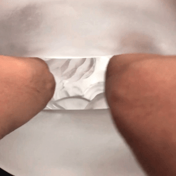 Model stretching interior of masturbation sleeve to display texture