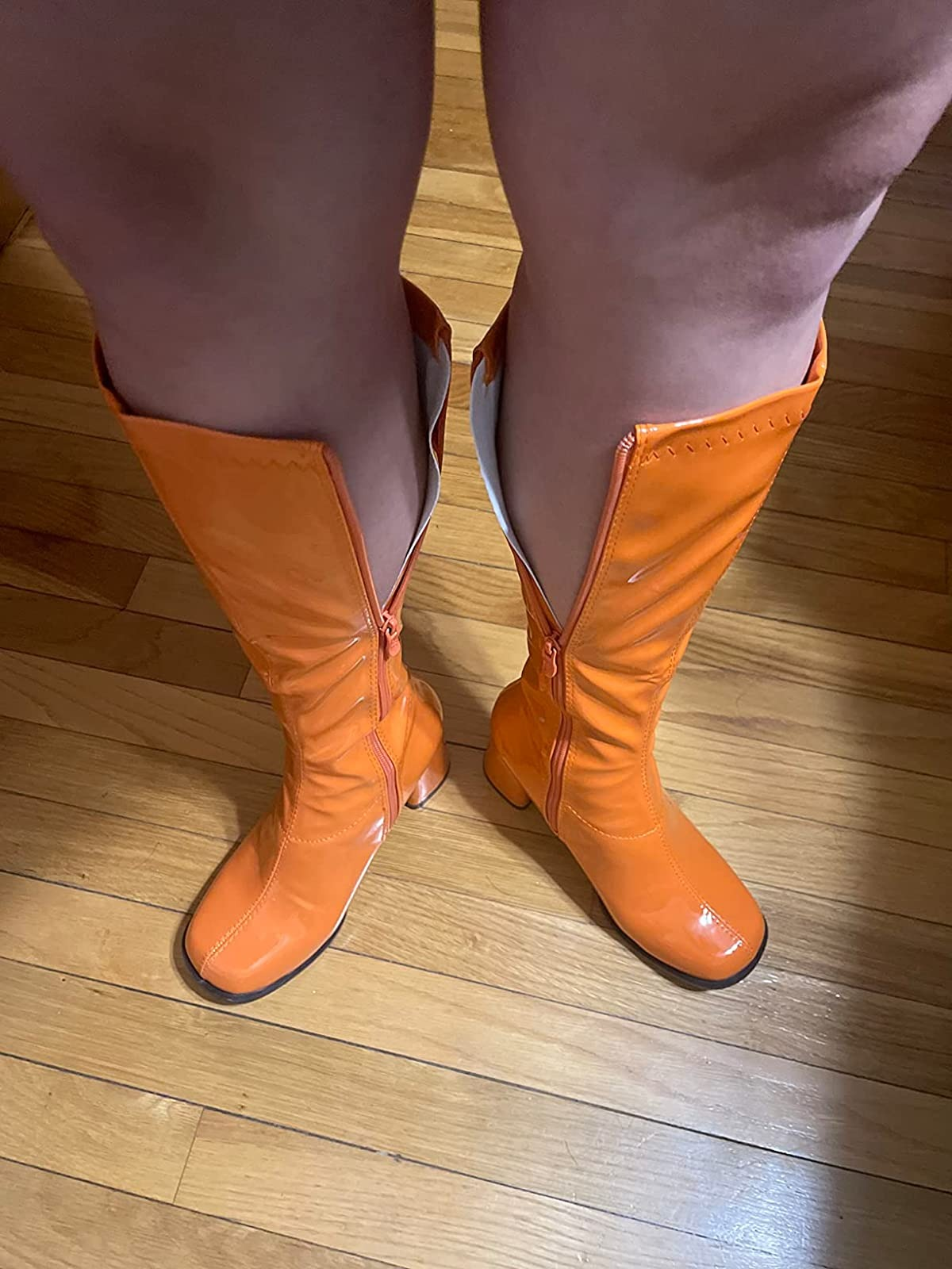 reviewer showing a pair of knee-high boots that don't fit around their calves