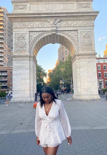 reviewer in deep v romper in white with dots