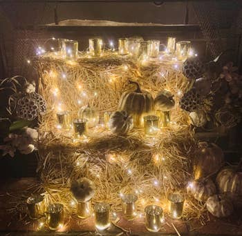 reviewer's pumpkins in gold sitting on hay bales with glowing lights around