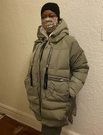 a reviewer wearing the zip-up puffer jacket in khaki green