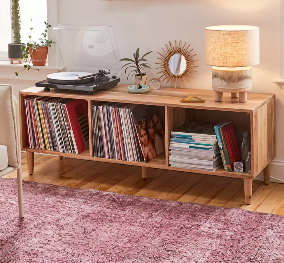 Wide light wooden credenza with record player, knick knacks, and vinyls inside
