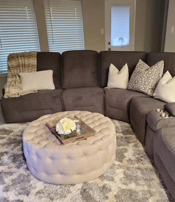 a beige ottoman in a reviewer's living room