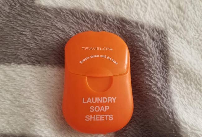 reviewer's orange container of laundry soap sheets