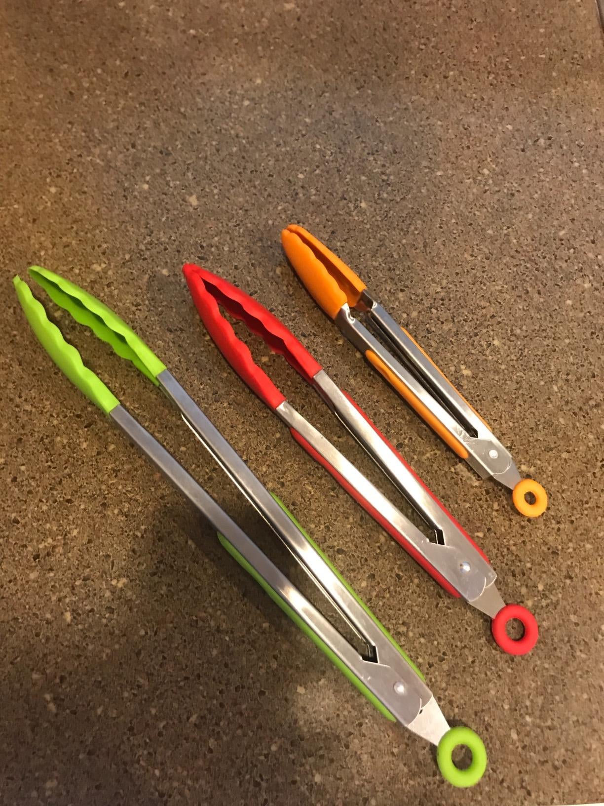 Reviewer photo of the three tongs — one big green one, one medium red one, and one small orange one