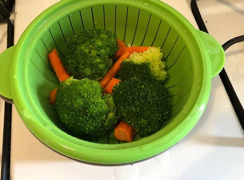 A microwavable veggie steamer filled with steamed broccoli and carrots