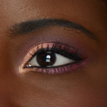close-up of model's eye with a shimmery light pink and purple look 