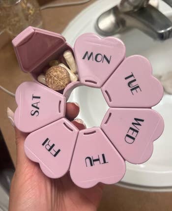 Reviewer holding the pinkish mentation with 1 of the capsules unfastened revealing medicine