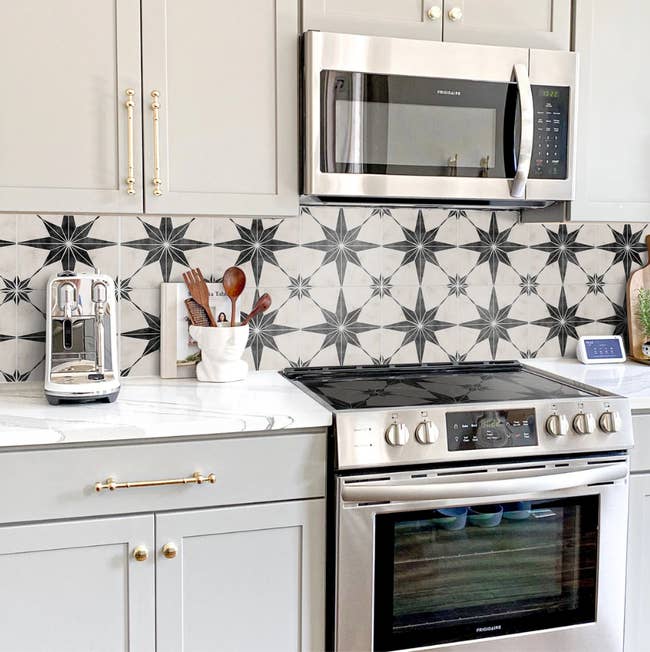 kitchen backsplash with the white tile stickers, which have a geometric star-shaped pattern on them