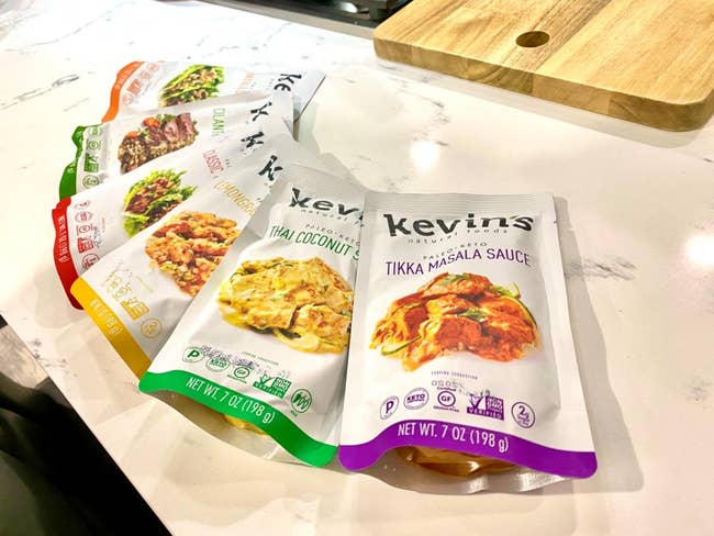 A variety of Kevin's Natural Foods sauce packets on a kitchen counter