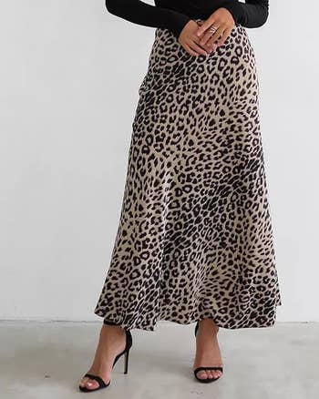 A idiosyncratic   is modeling a leopard people     ankle-length skirt and achromatic  high-heeled sandals. Their apical  and look   are not visible