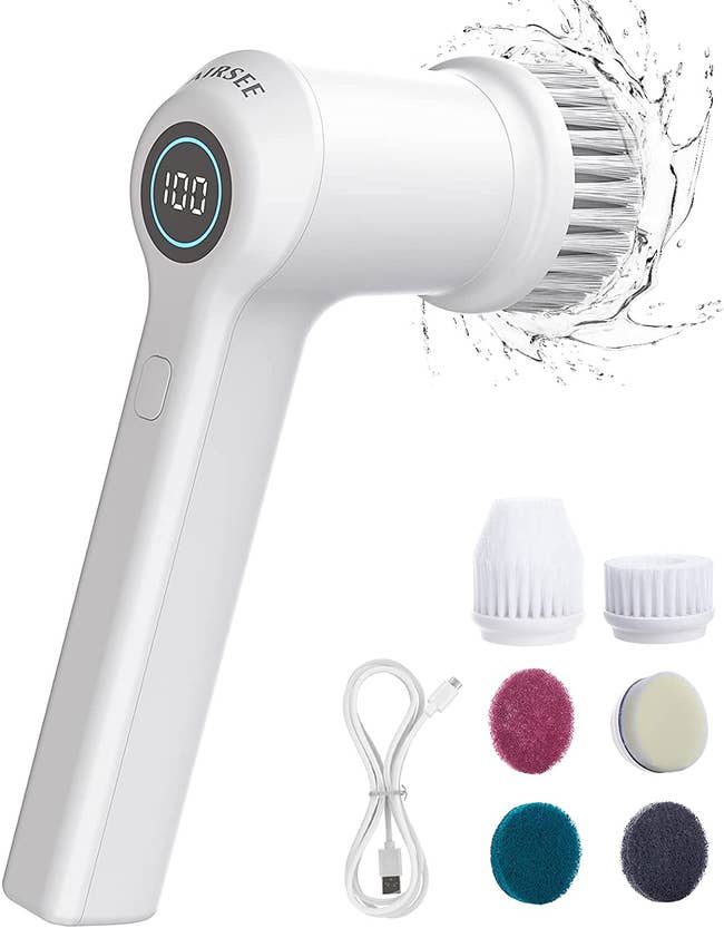 White electric scrubbing brush next to six head attachments and charging cord
