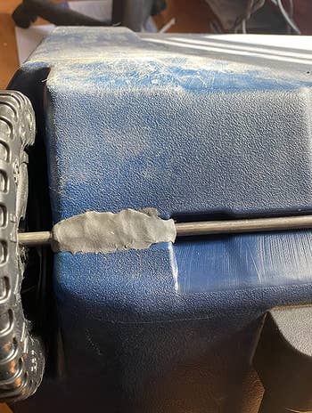 a reviewer photo of gray molded glue being used to repair a wagon