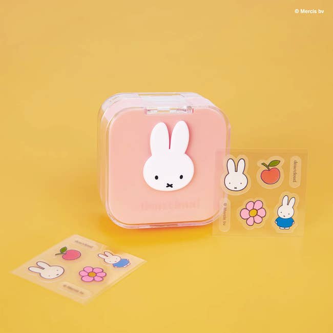 Cute retention  container  with Miffy design, accompanied by colorful stickers featuring Miffy, an apple, and flower