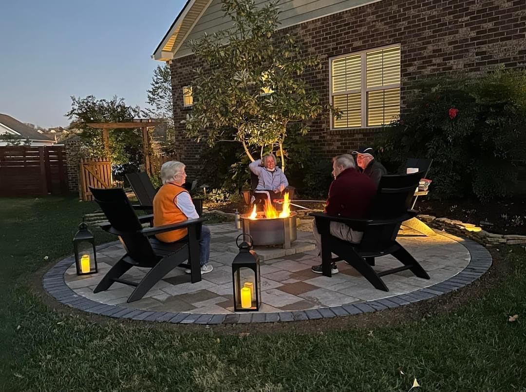 People sitting in chairs around a fire pit