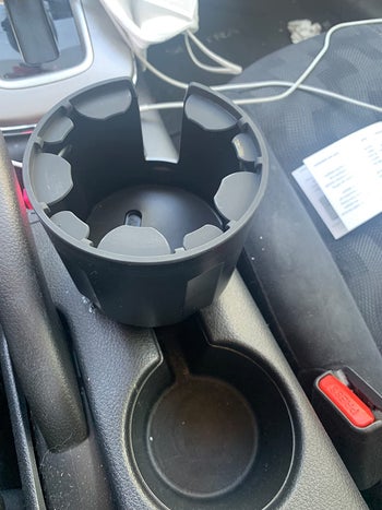Reviewer's expandable cup holder adaptor installed in their car