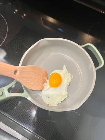 Me, using the included wooden spatula to lift a cooked egg from the same pan's non-stick interior