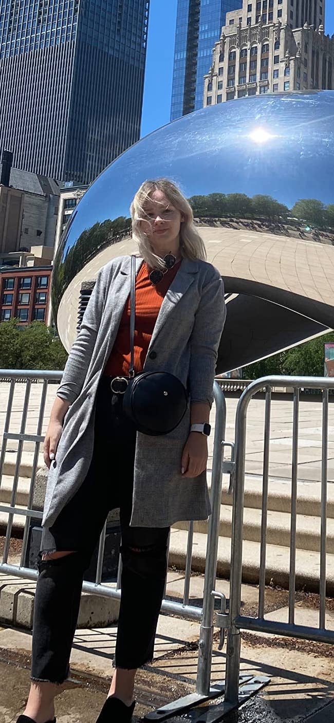 a reviewer wearing the black round crossbody purse