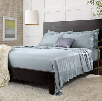 A neatly made bed with smooth sheets and pillows in a contemporary styled bedroom for a shopping article