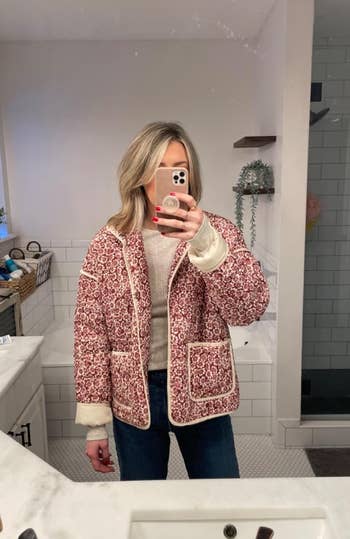 reviewer wearing pink floral quilted jacket