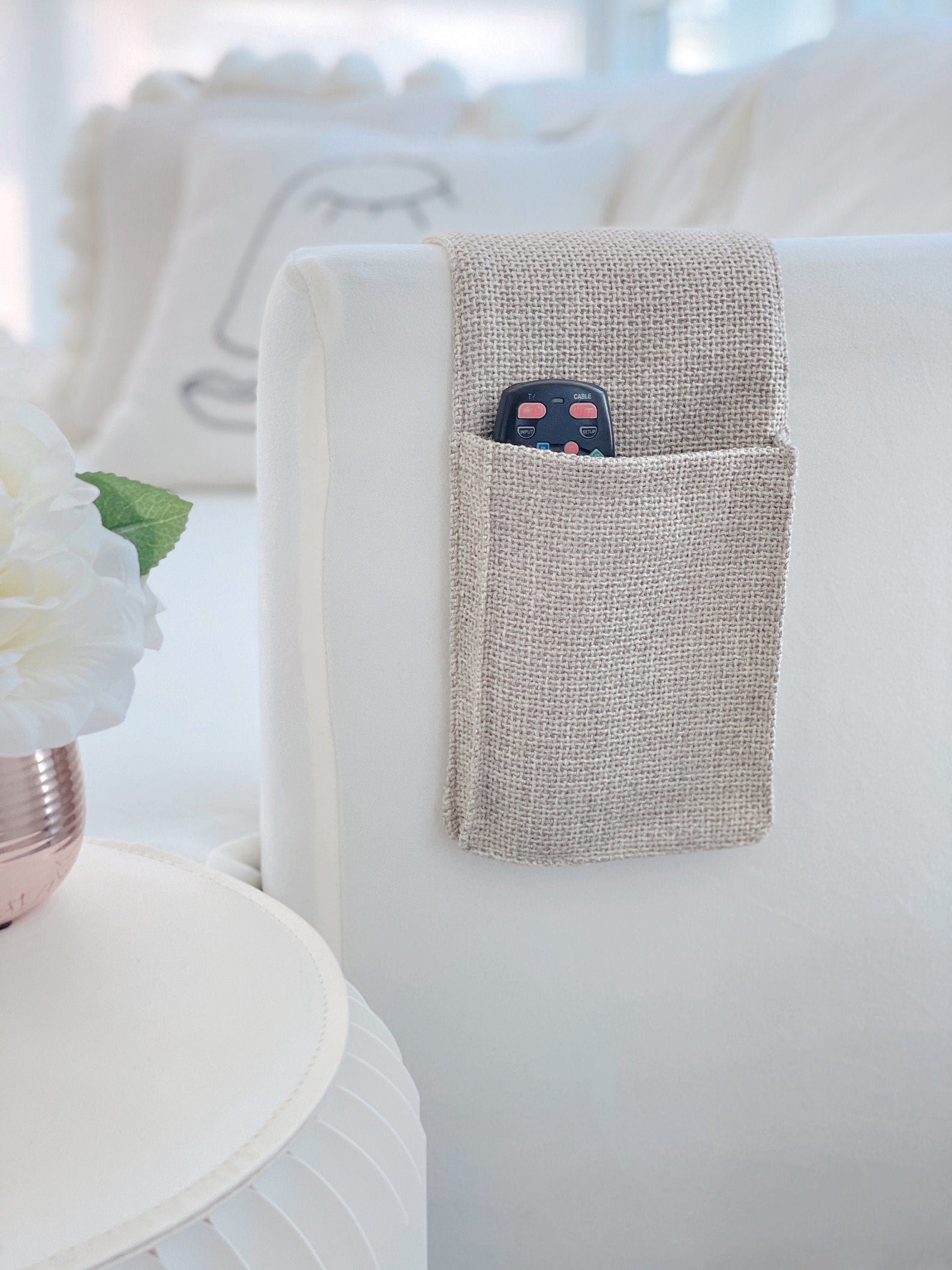 the linen remote control caddy on a couch arm