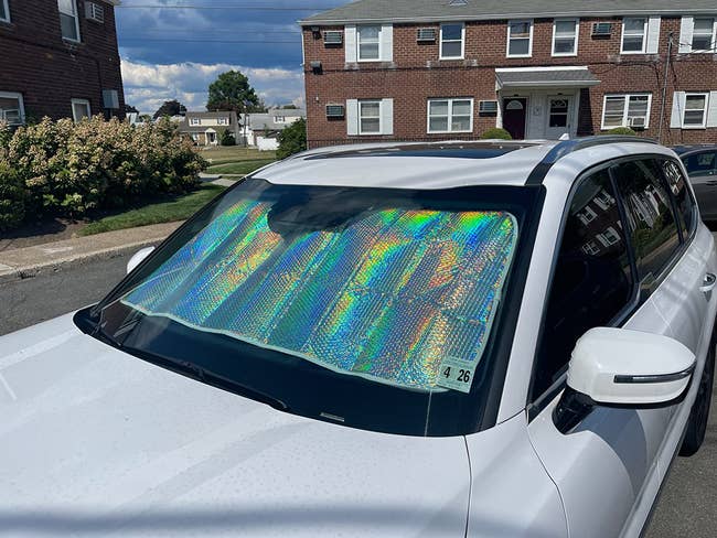 Car with a reflective sunshade connected windshield