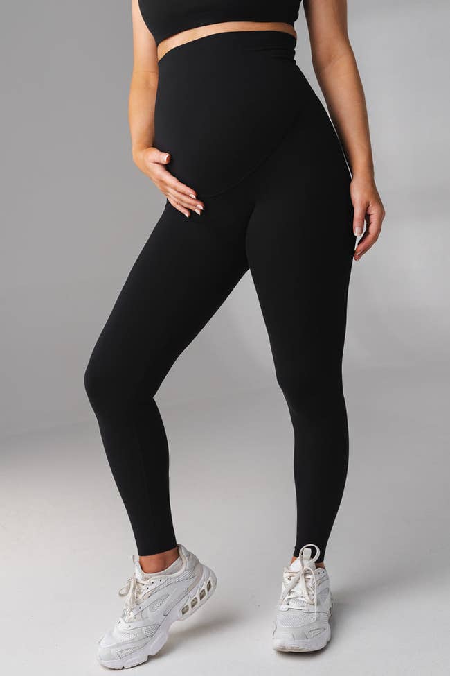 a model wearing the black, super high rise maternity leggings