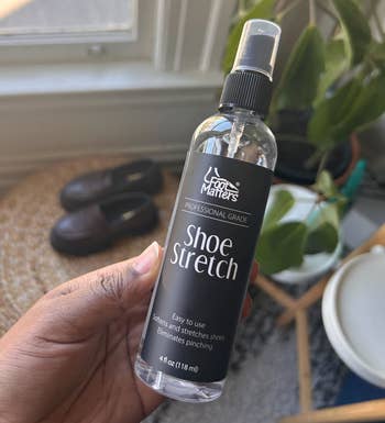 BuzzFeed writer holding the spray vessel of footwear stretch