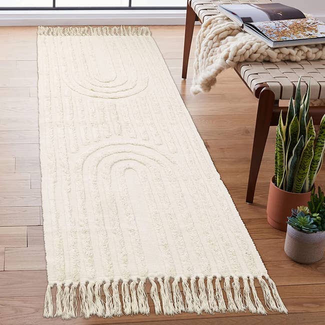 the beige runner laying beside a bench and plants