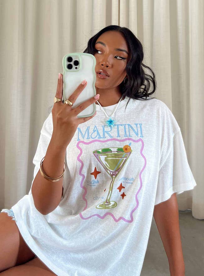 model wearing shirt with illustration of martini on the front